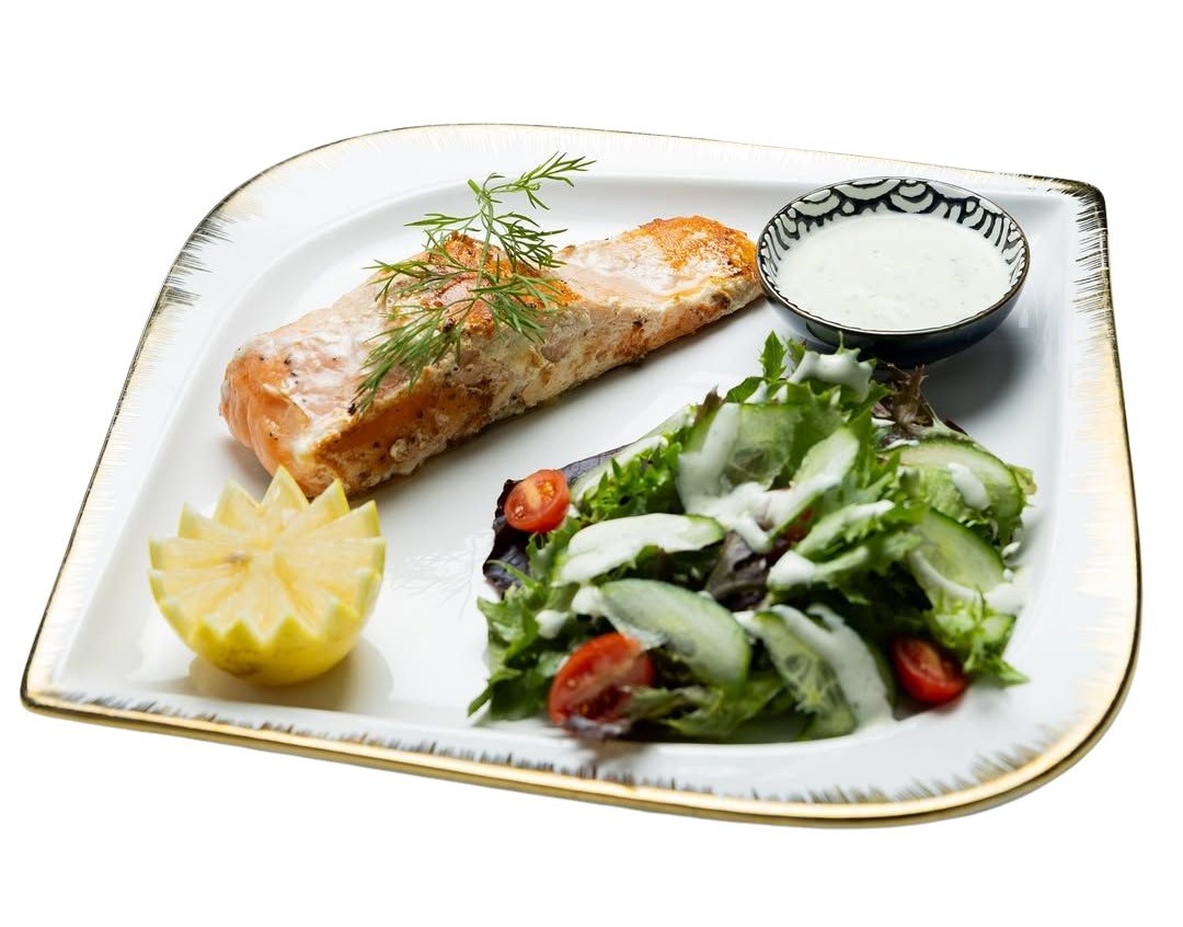 Grilled salmon fillet with creamy garlic sauce and fresh side salad